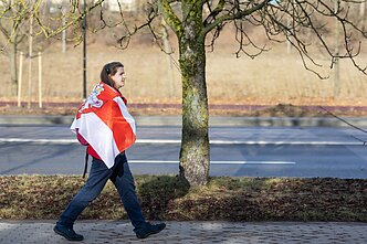 A woman with an alternative flag of Belarus abopted by pro-democracy activists A woman with an alternative flag of Belarus abopted by pro-democracy activists